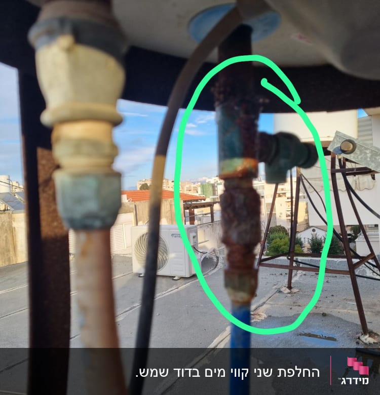 צינור חלוד עם חיבורים על גג בניין
